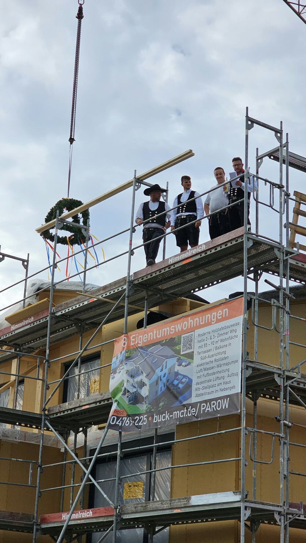 Zimmerleute beim Richtfest auf dem Dach